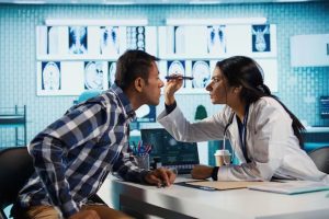 ophthalmologist examining a patient's eyes during a comprehensive eye exam to identify vision and eye health concerns.